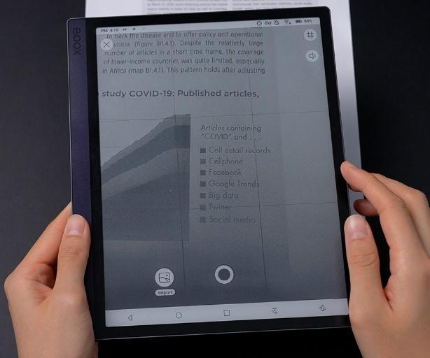 Hands holding a tablet with a screen on itDescription automatically generated