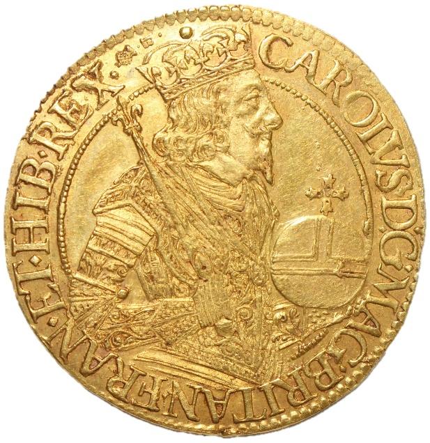 A gold coin with a person in a crown and a ship

Description automatically generated