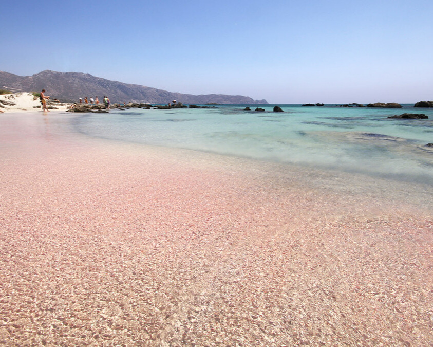 A serene view of Elafonisi Beach with its unique pink sand and vibrant blue water.