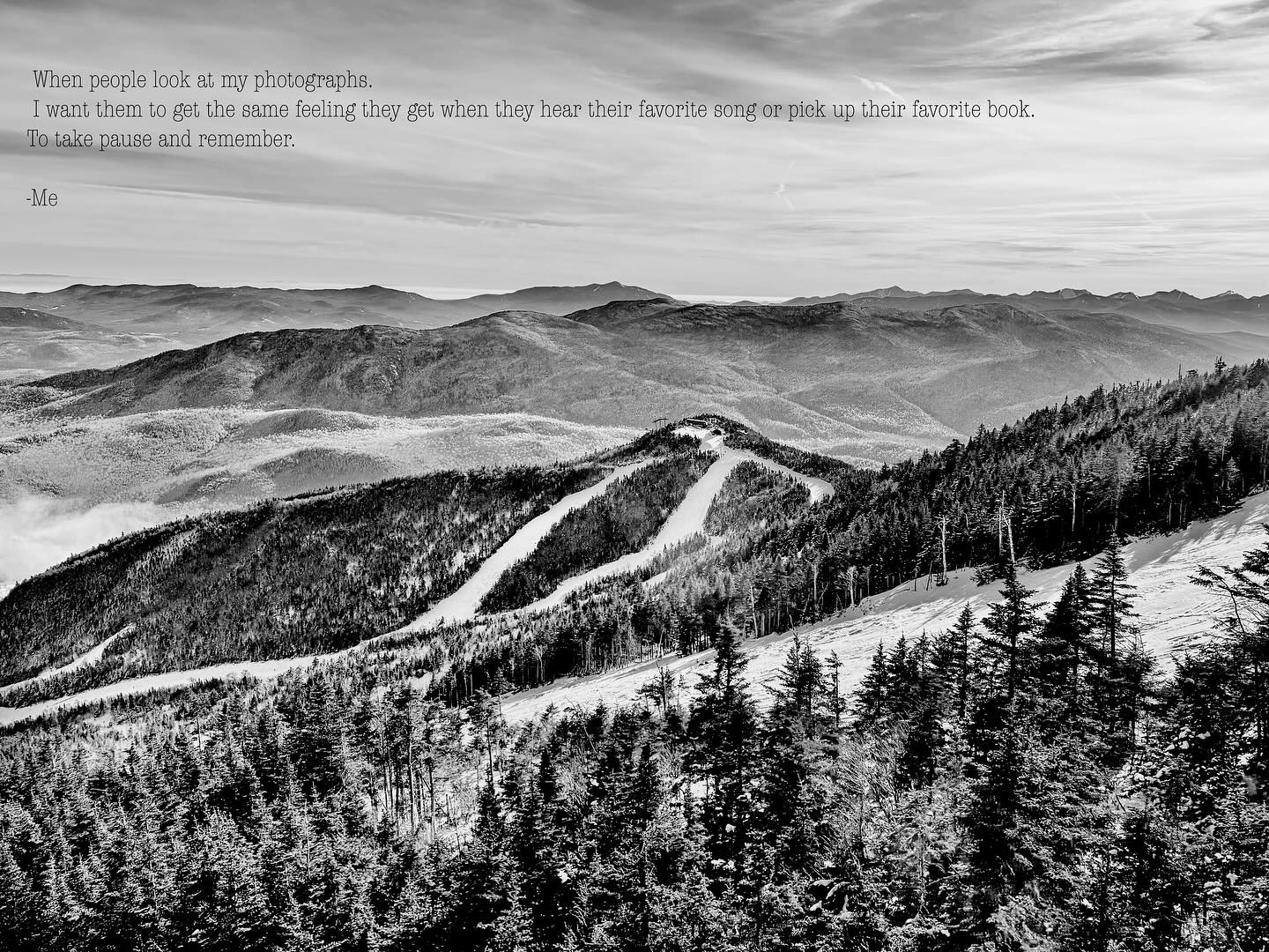 A breathtaking black-and-white mountain landscape with rolling hills and tree-lined slopes, evoking a sense of calm and wonder. Captured by @speerimages.