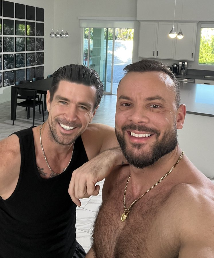 Trenton Ducati posing with shirtless gay xxx onlyfans content star Sir Peter showing off his muscles in a black tank top