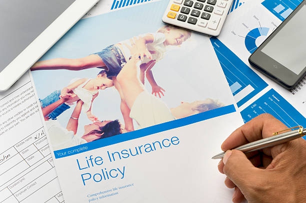 A person writing on a life insurance policyDescription automatically generated