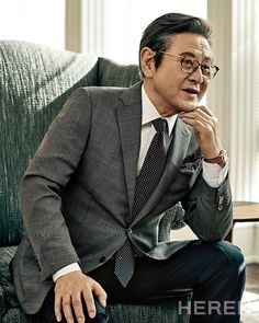 This contain an image of  Park Jung Ha  in a suit and tie sitting on a couch with his hand under his chin