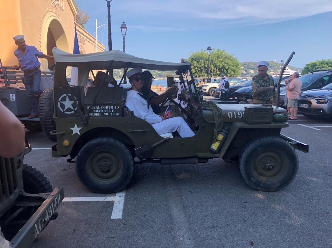 A group of people in a military jeep

Description automatically generated