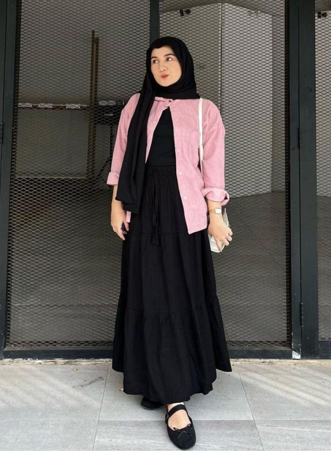 Wanita dengan pakaian hitam dan kemeja mauve.
