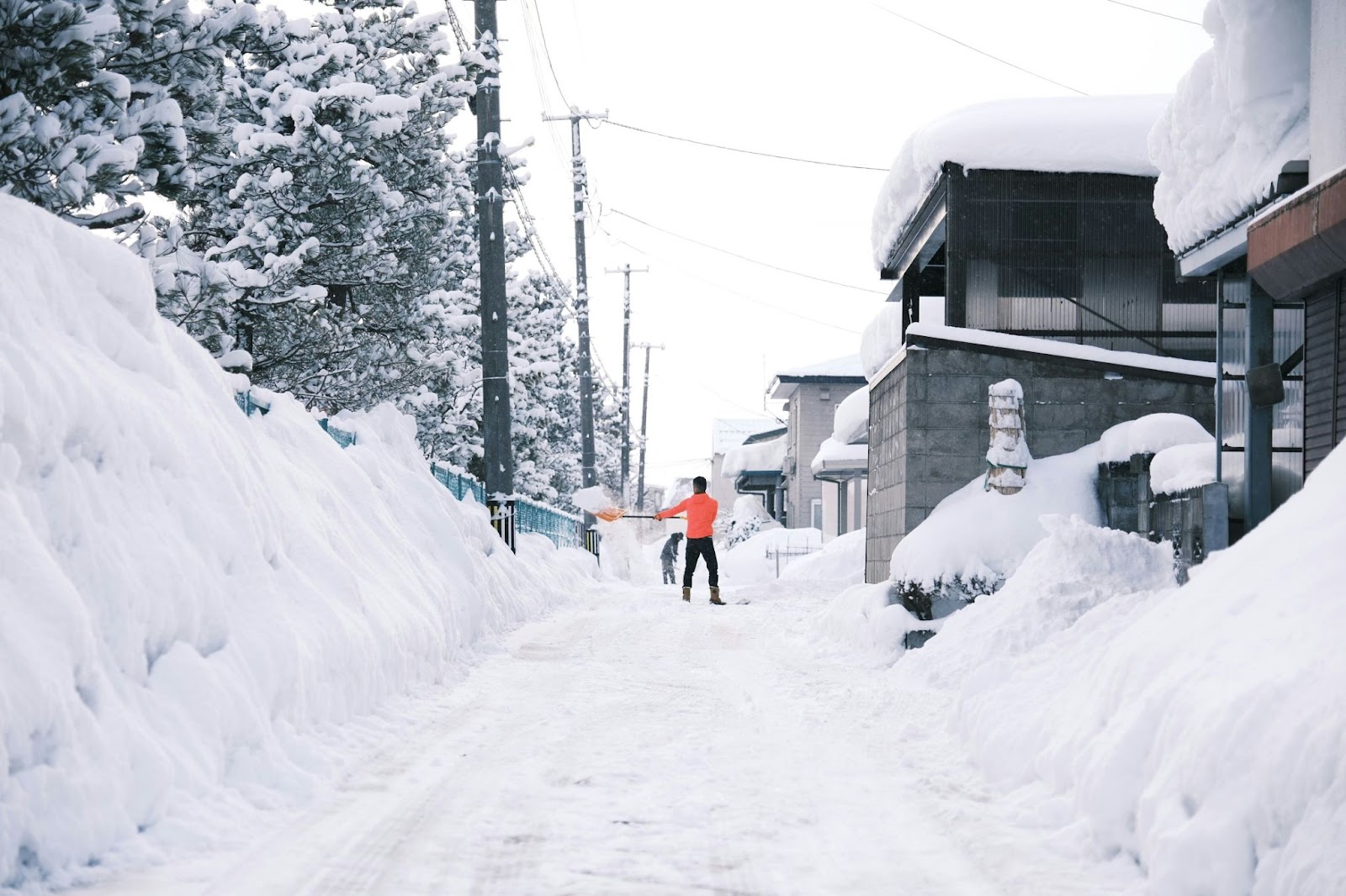 A man is shoveling the snow, clearing pathway for senior home safety in Vancouver winter
