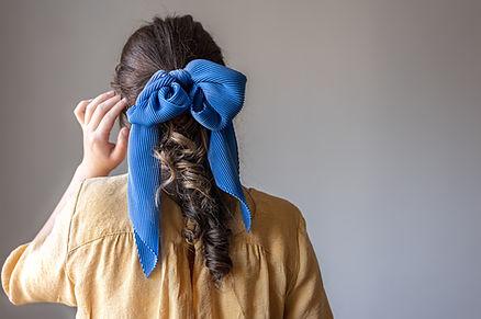 A female with well dressed hair with fancy hair tie