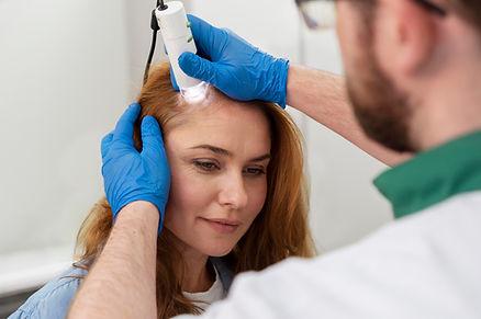 A doctor is examining female scalp