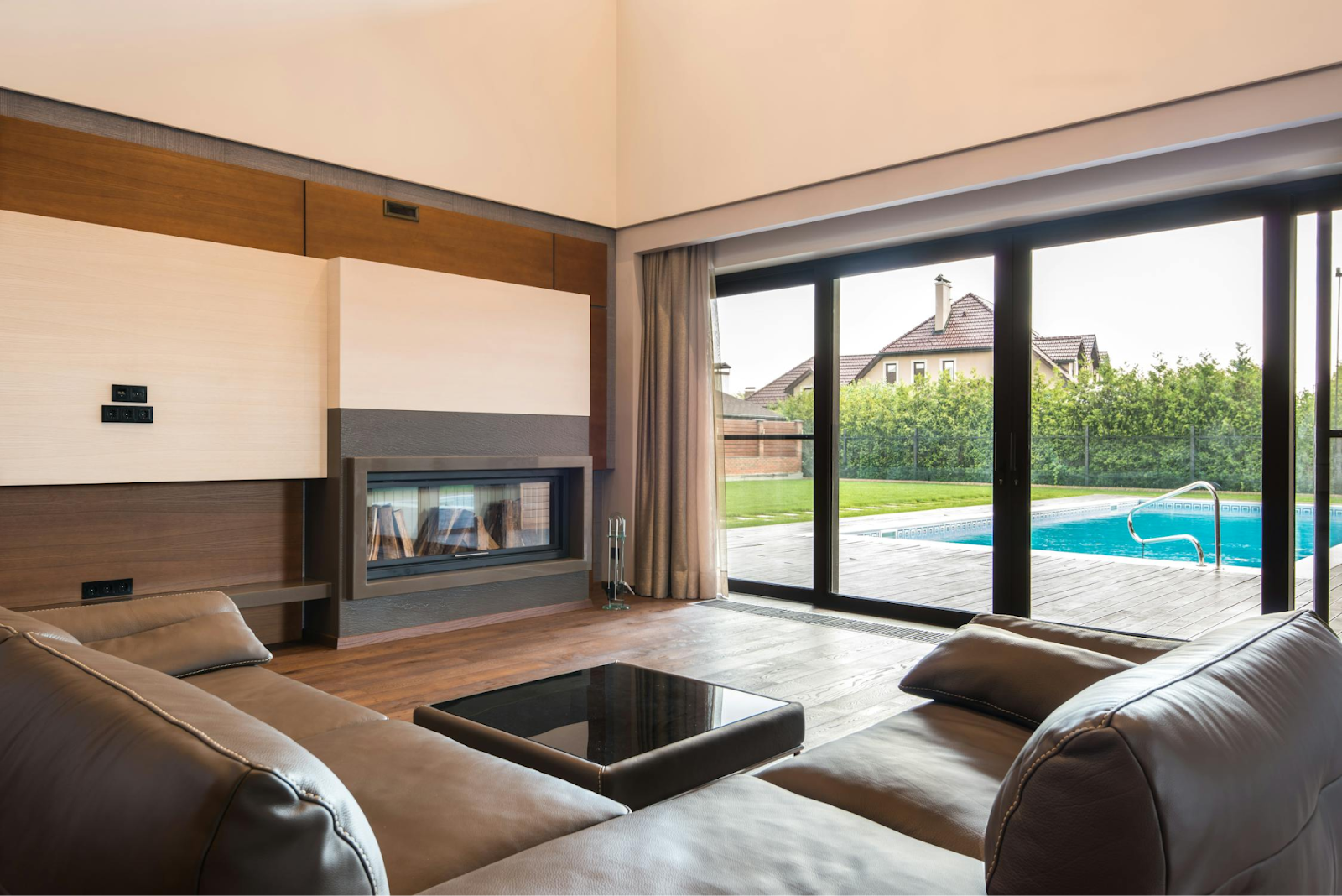 This image depicts sliding doors that separate a modern living room from an outdoor deck area.