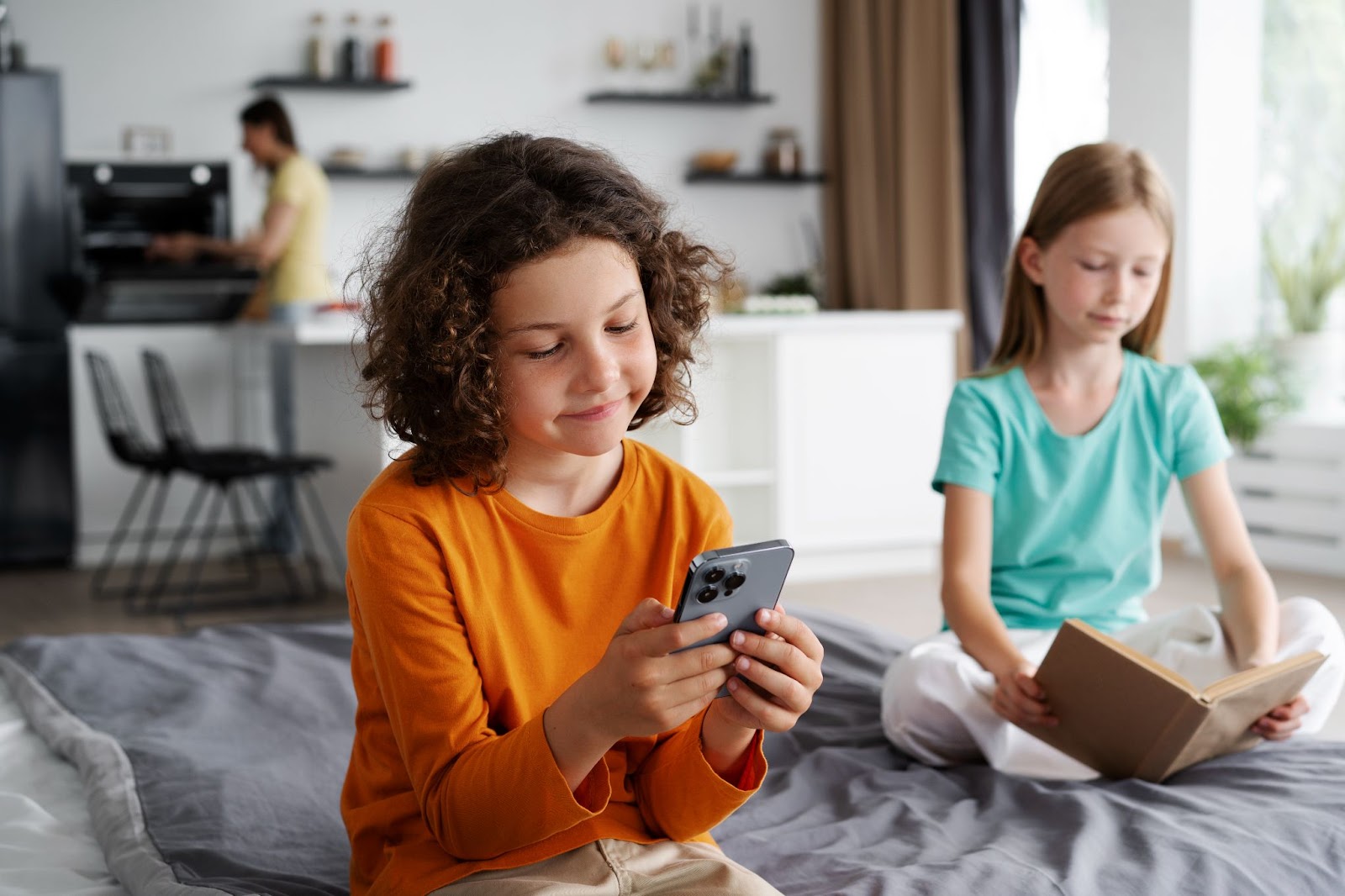 Siblings spending time to together at home on their tablets getting monitored by parental control apps.