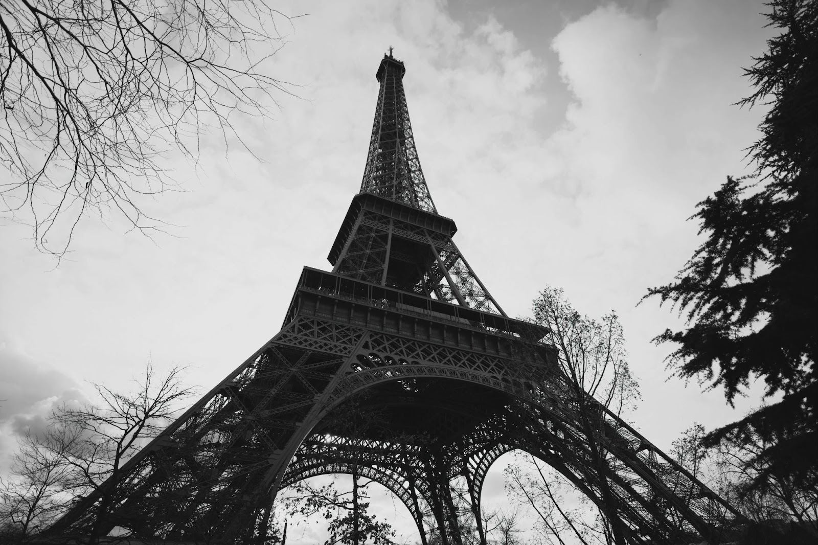 Black and white photo of the Eiffel Tower, taken from below.