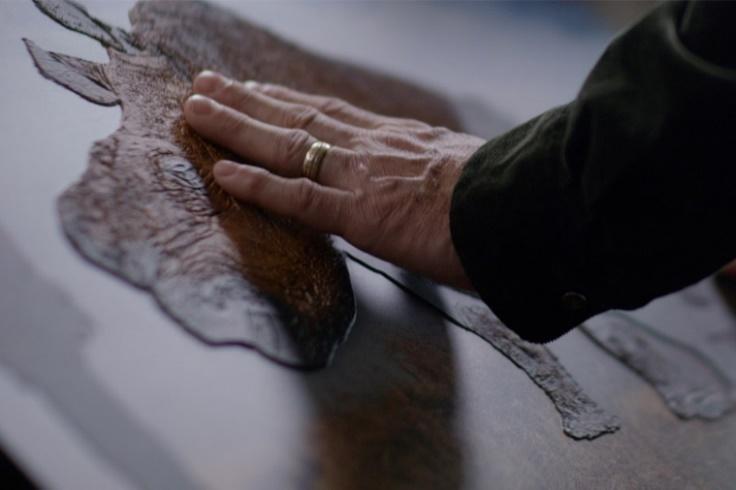 A close-up of a hand touching a piece of wood

Description automatically generated