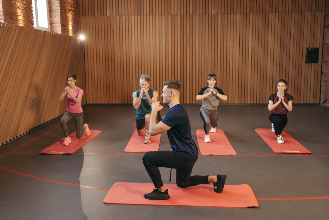 Free A diverse group practicing fitness and yoga exercises indoors with mats. Stock Photo