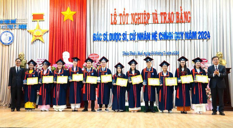 A group of people in graduation gowns holding certificates

Description automatically generated