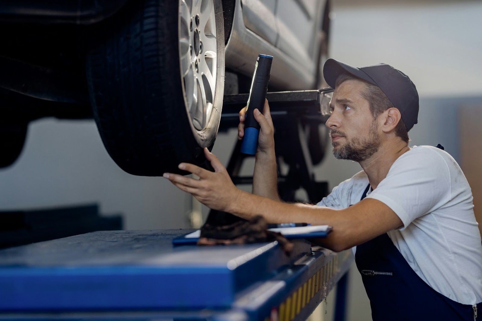mecánico inspeccionando neumáticos de coche