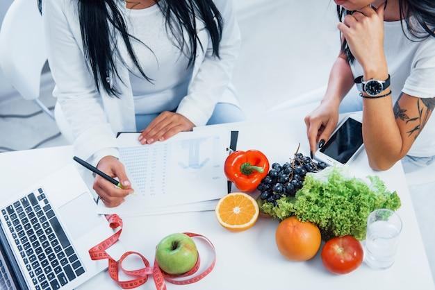 Premium Photo | Top view of female nutritionist that gives consultation to  patient indoors in the office.