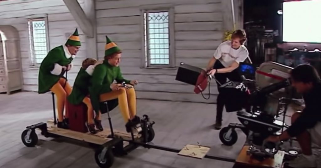 A behind-the-scenes shot of the scene where a young Buddy rides his bike with Papa Elf on his back. It reveals that the actors were spaced out in a way to force the perspective. 