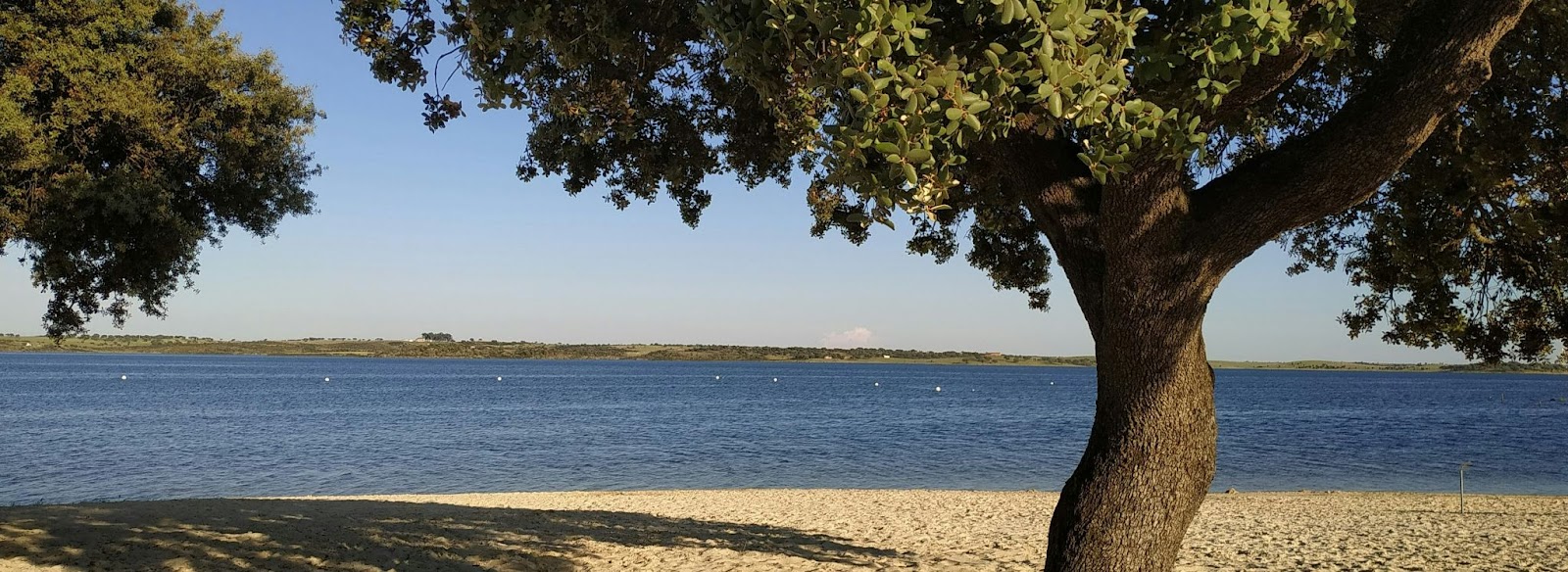 Praia fluvial de águas calmas e areia dourada às margens do Lago Alqueva, cenário encantador para quem quer saber onde fica Monsaraz.