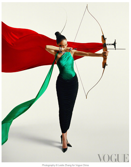 A person in a dress with a bow and arrow

Description automatically generated