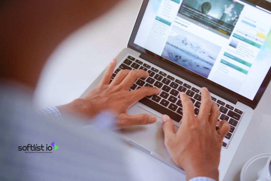 Person typing on a laptop keyboard, browsing a website