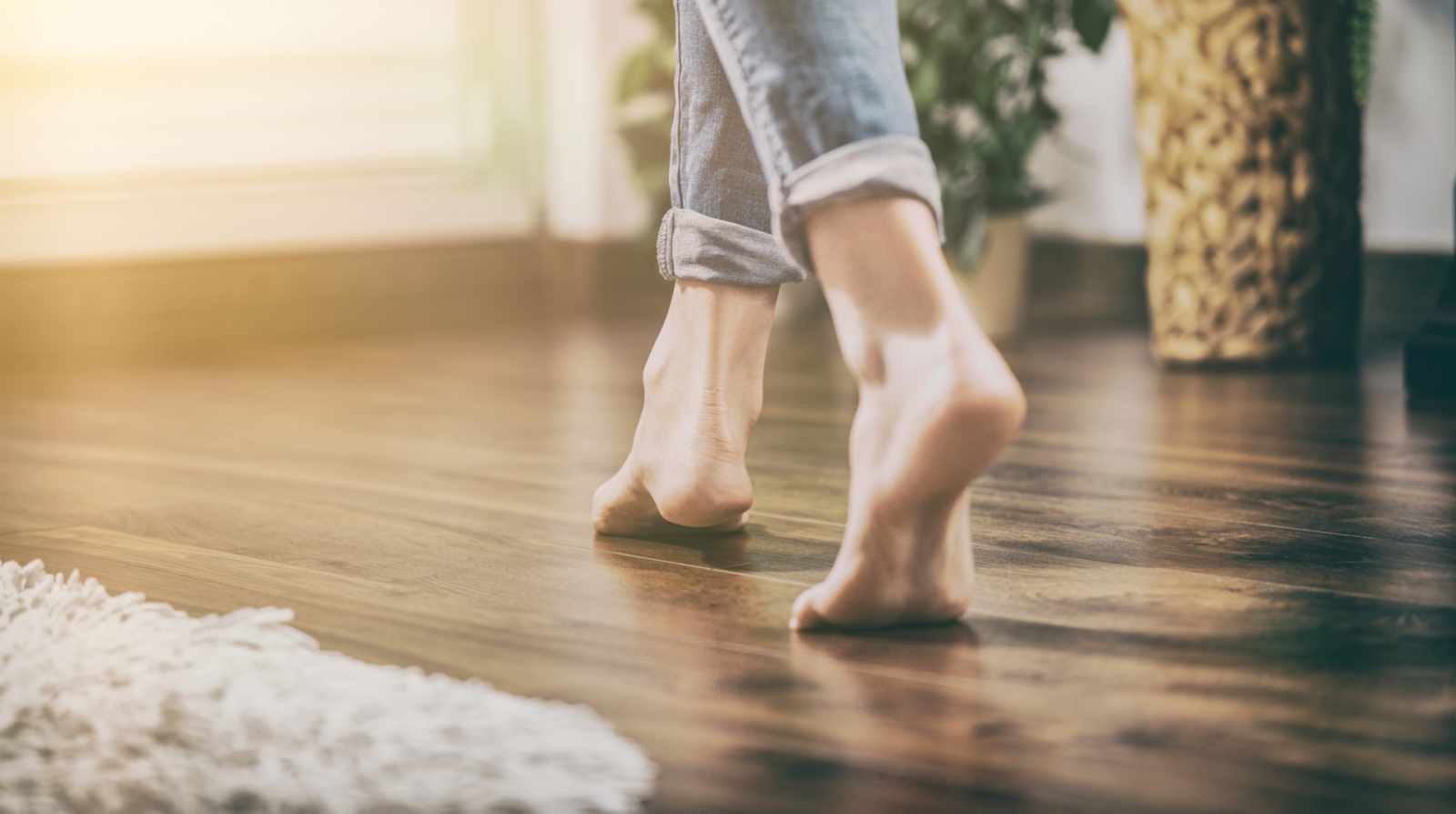 Up close image of bare feet on heated wood floors.