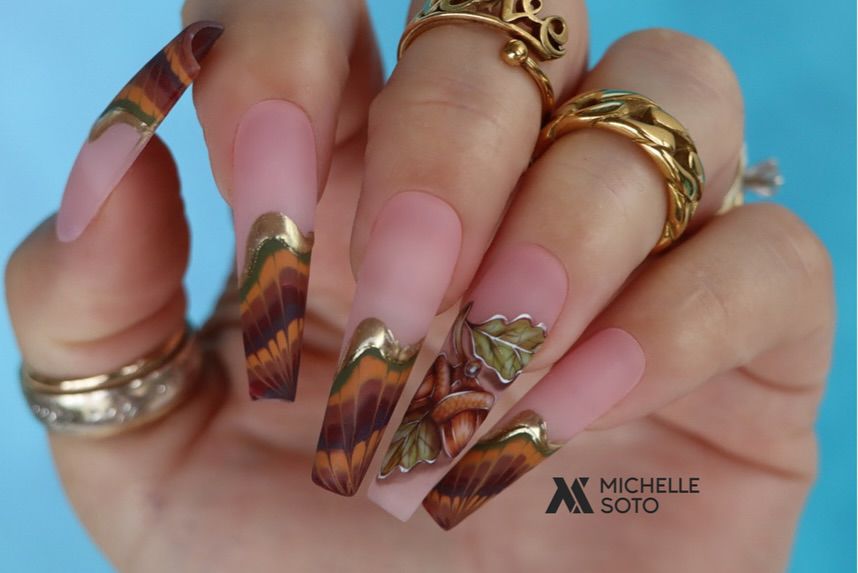 Close-up of hands with fall nail design having Ballerina Nails