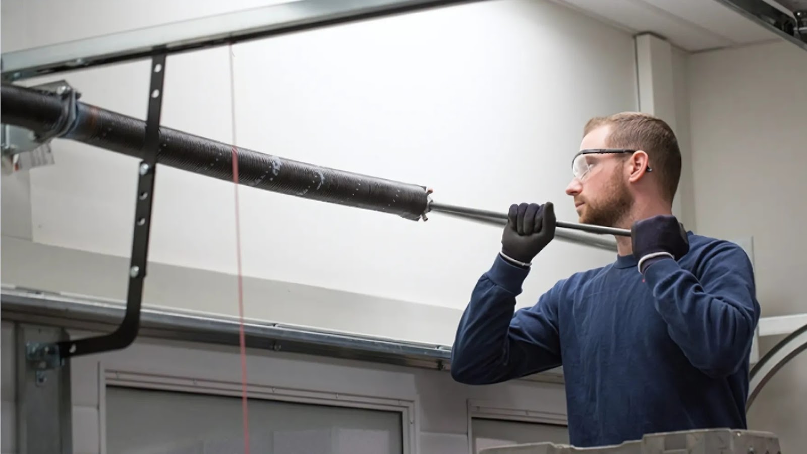 Technician handling the repair of a garage door spring.