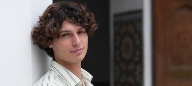 Example image of a male model smiling towards the camera with bokeh background