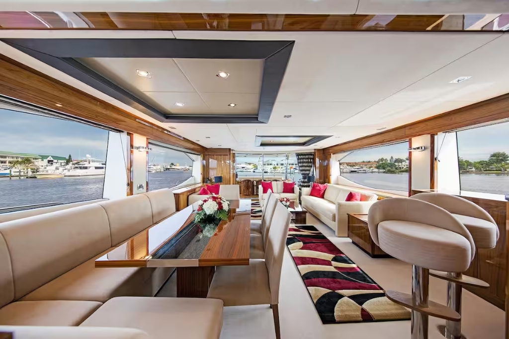 large living room of a yacht with wooden tables and red accents
