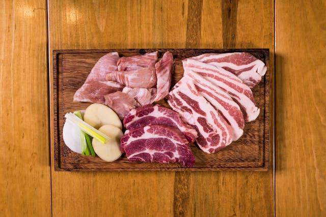 A cutting board with meat and vegetables

Description automatically generated