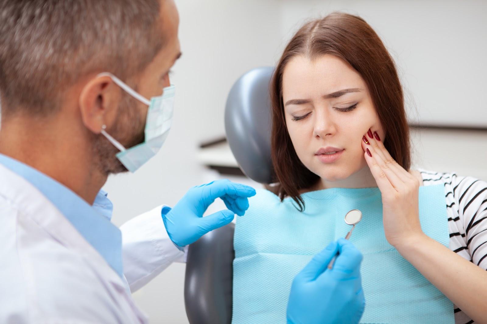 A dentist checking his female patient with dental pain
