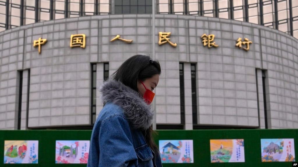 资料照:一名女子走过位于北京的中国人民银行。(2024年2月20日)