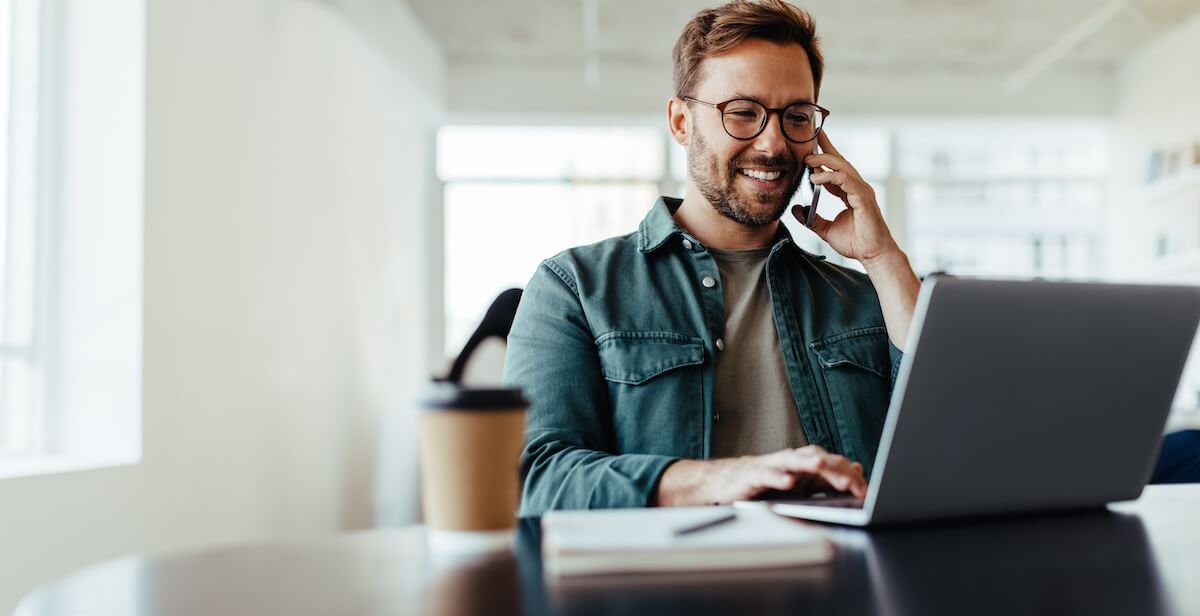 Employee talking on the phone while using his laptop
