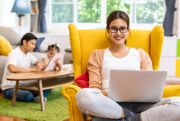 A relaxed mom using her laptop, showcasing time blocking to efficiently balance work and personal time