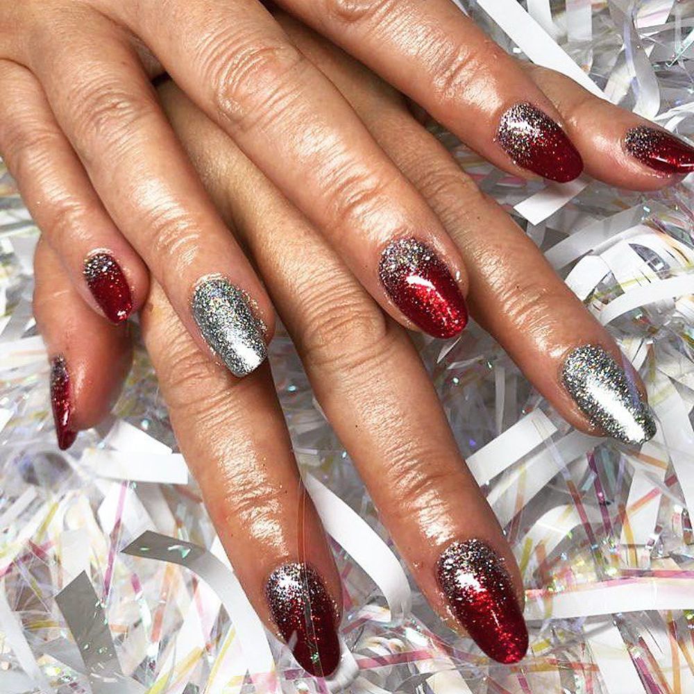 Close up of hands having Christmas red nails with Silver and Red Elegance