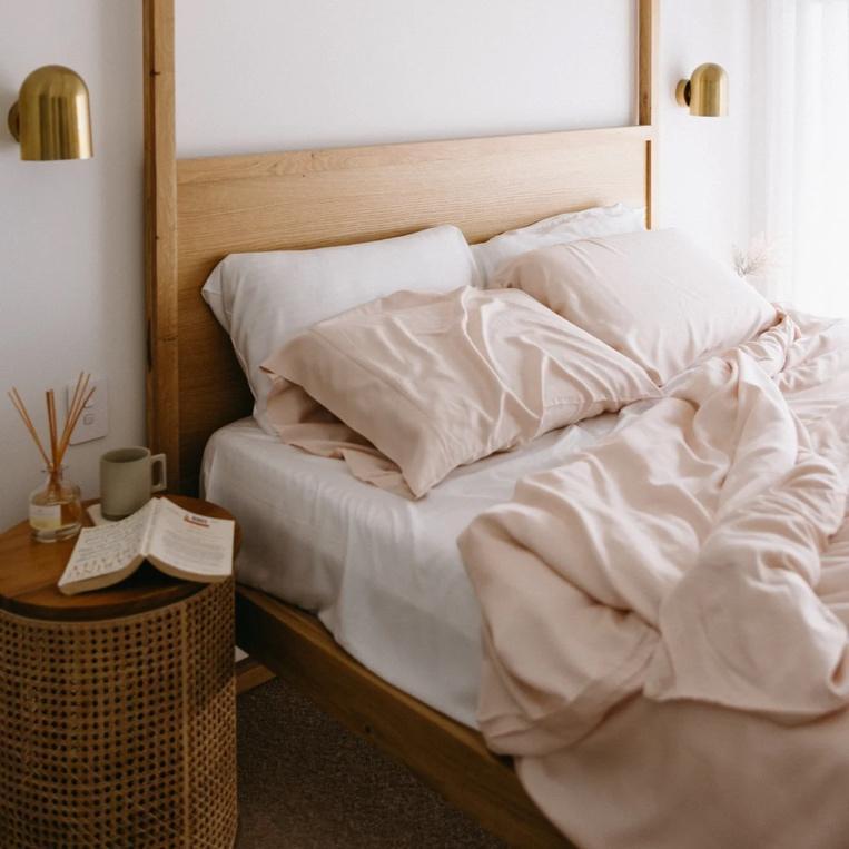 A bed with a wooden headboard and a lampDescription automatically generated