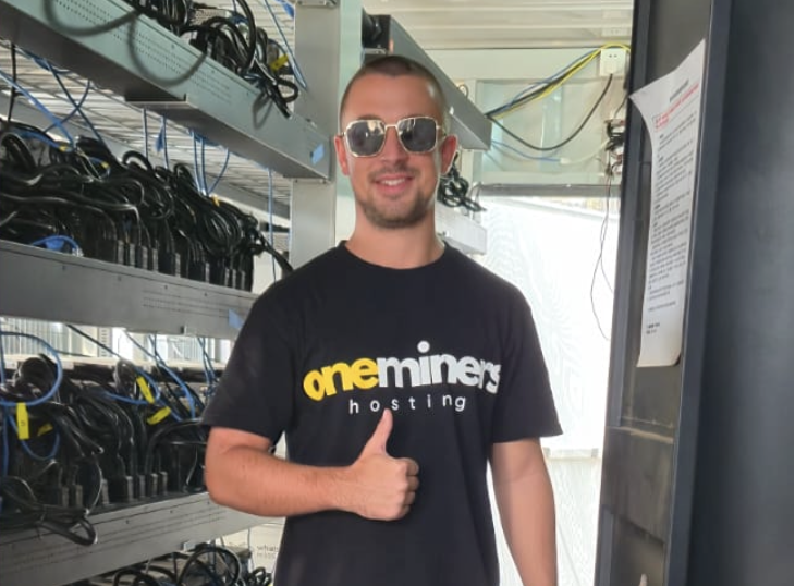 A person wearing sunglasses and giving a thumbs up Description automatically generated