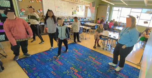 An image of students and teachers in a classroom setting, engaging in hands-on learning activities, showcasing an embodied learning environment.