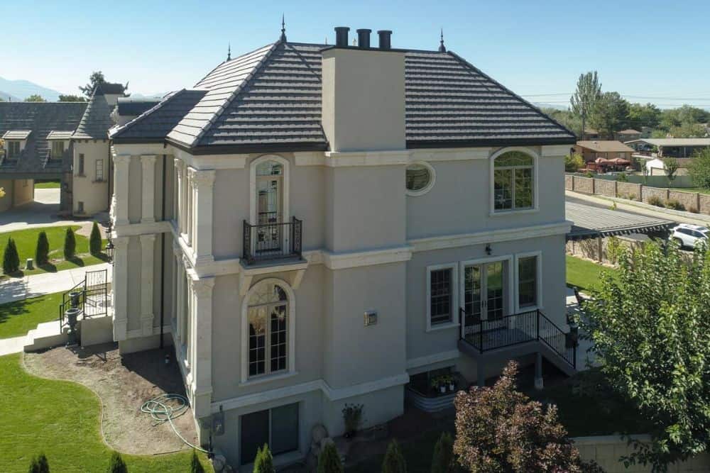 Right exterior view with balconies and a staircase leading to a french door that opens into the kitchen.