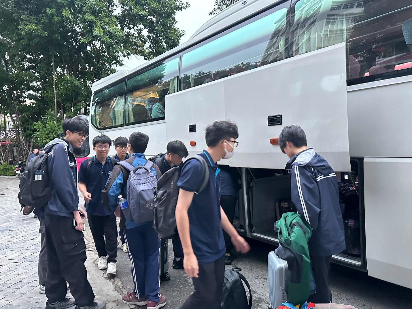 A group of people standing next to a bus

Description automatically generated