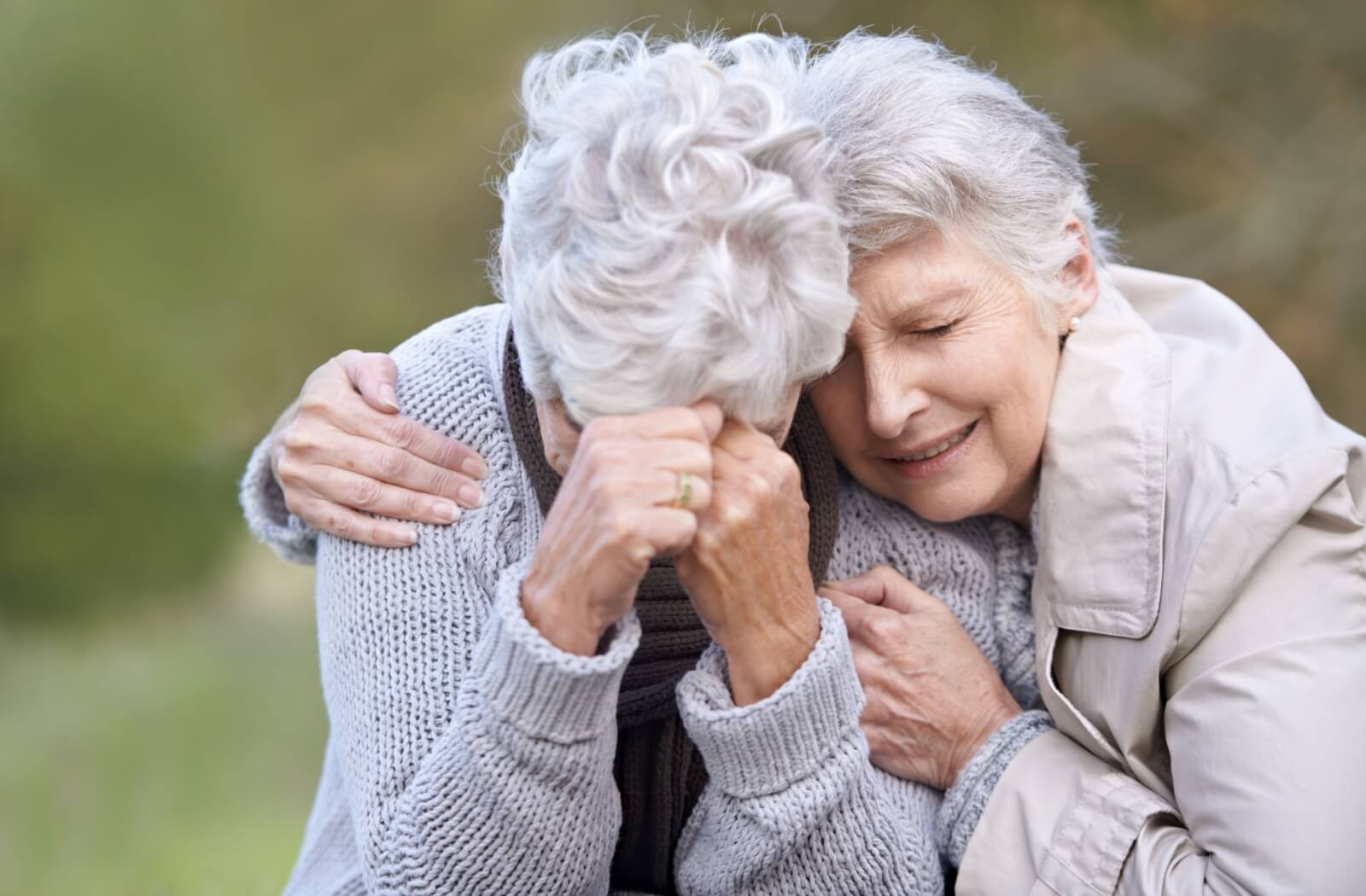 A troubled, lost senior is embraced by their friend as a means of comforting them amid memory loss