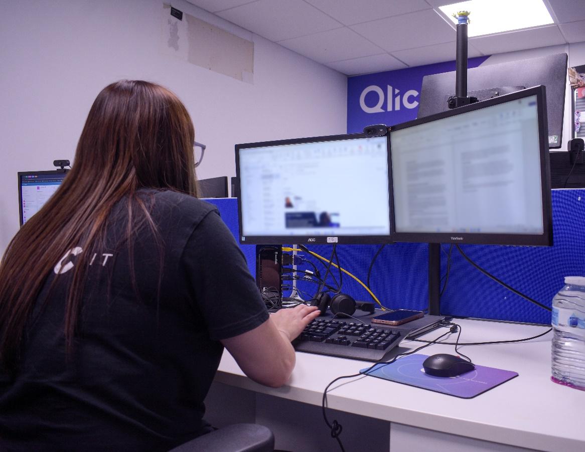 A person sitting at a desk with multiple computer screens

Description automatically generated