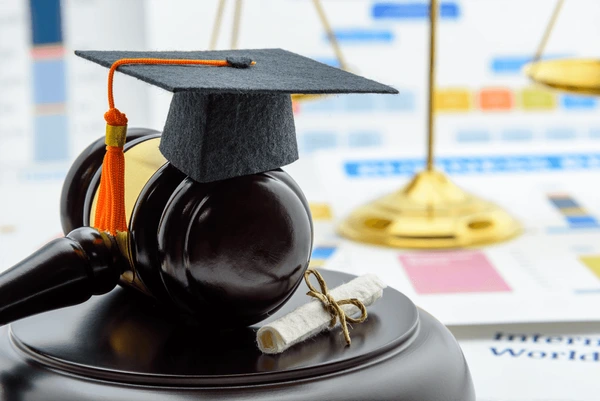 A graduation cap on a gavel Description automatically generated