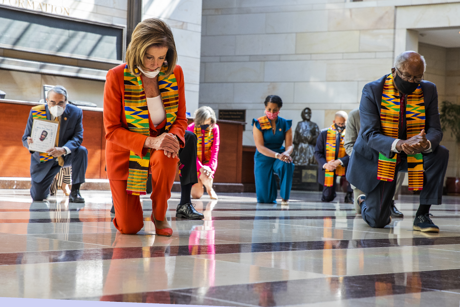 Nancy Pelosi and other democrat lawmakers kneeling while wearing kente cloths