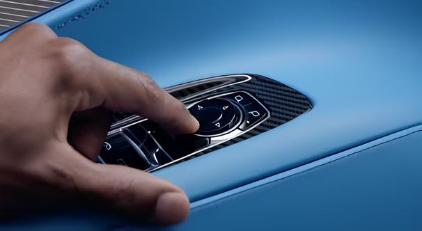 The internal mechanism of a power-folding car mirror, showing the white plastic gears and actuator.
