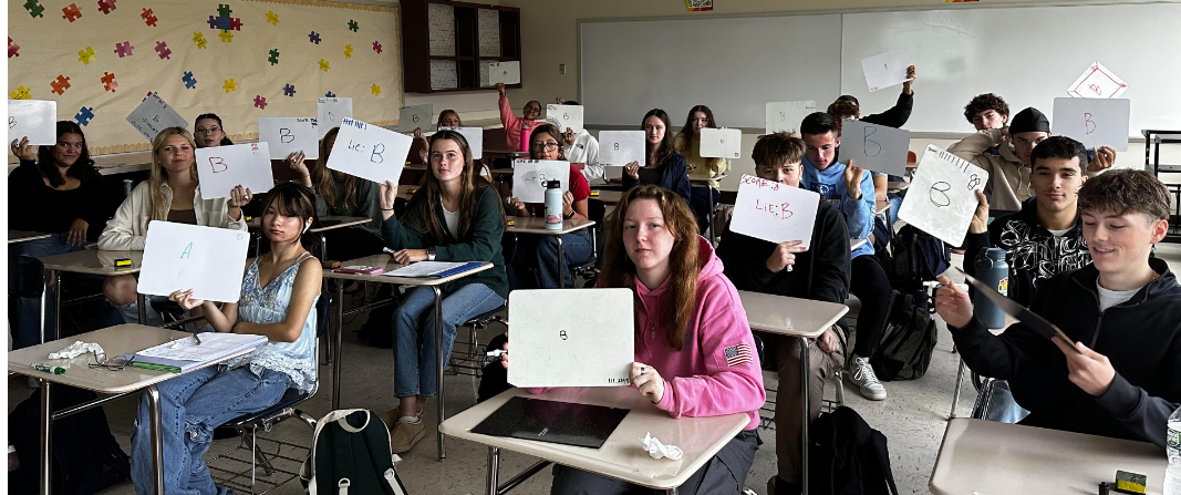 image of students in class holding up whiteboards