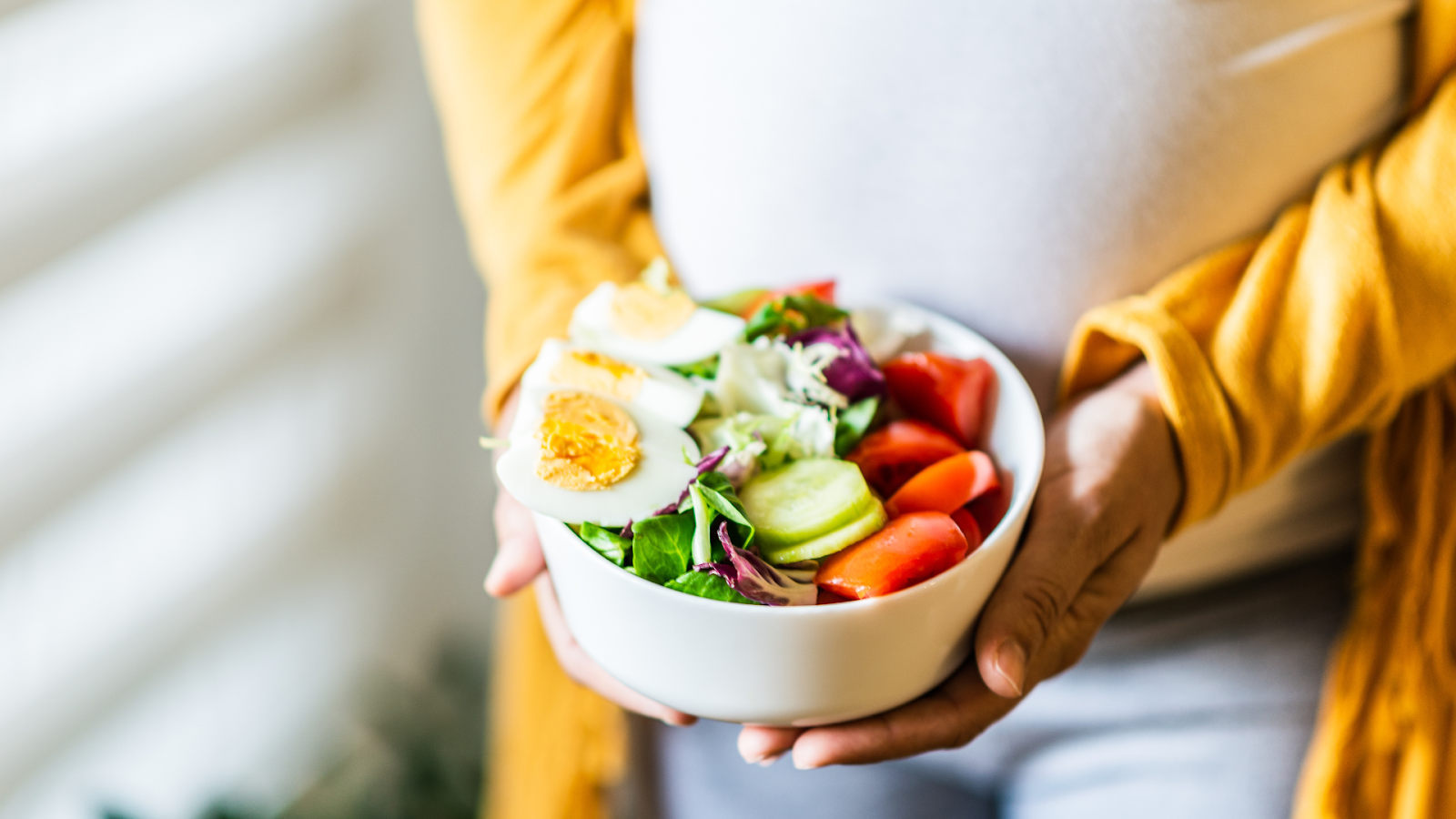 Person holding a white bowl that is full of healthy foods // Healthier Veterans Today