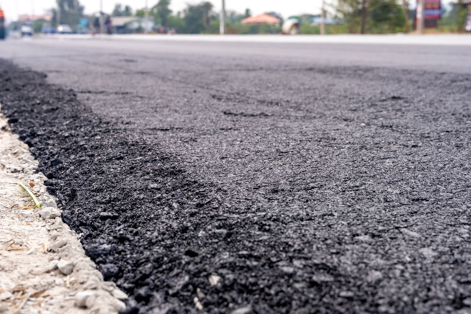 Asphalt next to a sidewalk. 