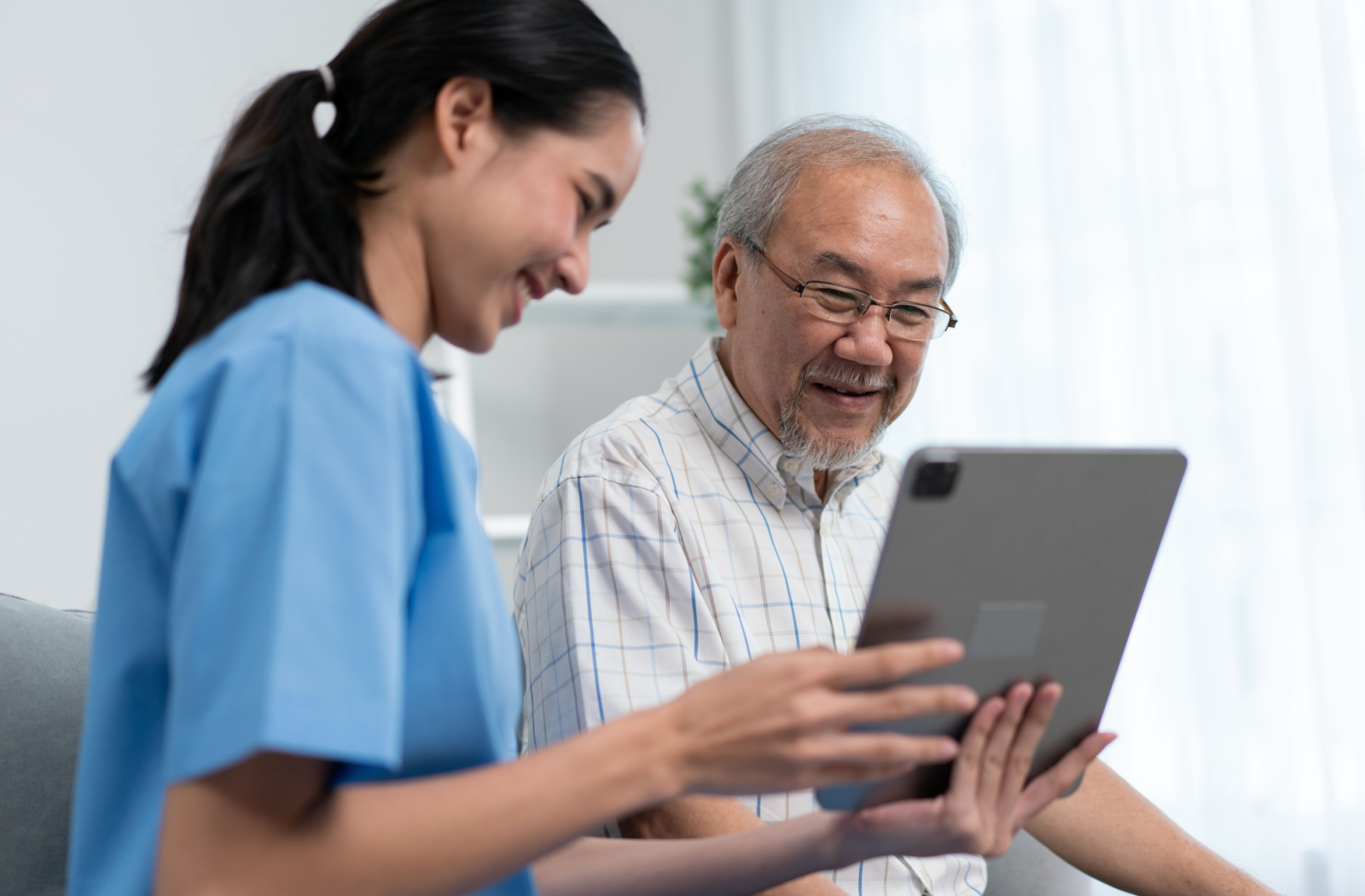 A happy resident reviews their wellness plan with the community nurse.