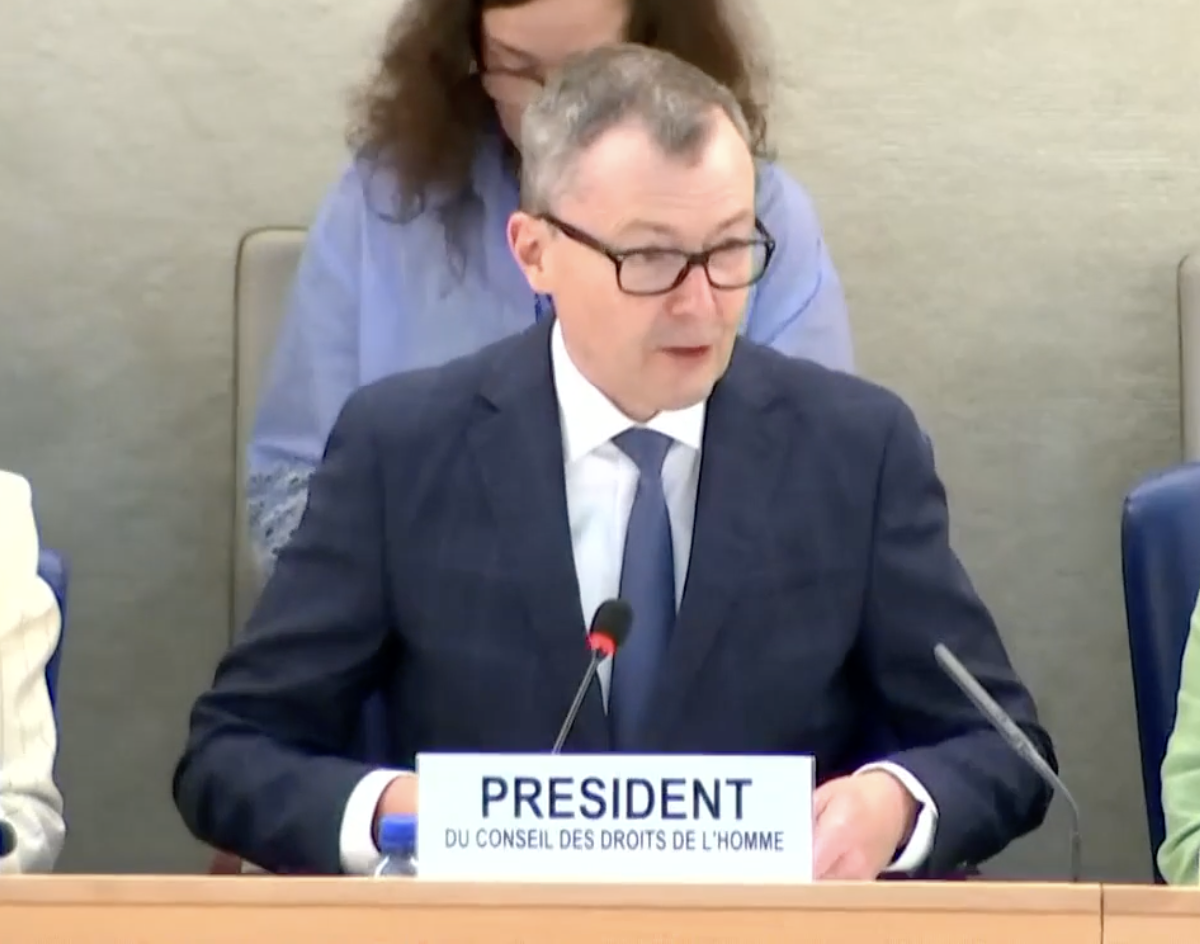 A person in a suit and tie sitting at a podium with a microphone

AI-generated content may be incorrect.